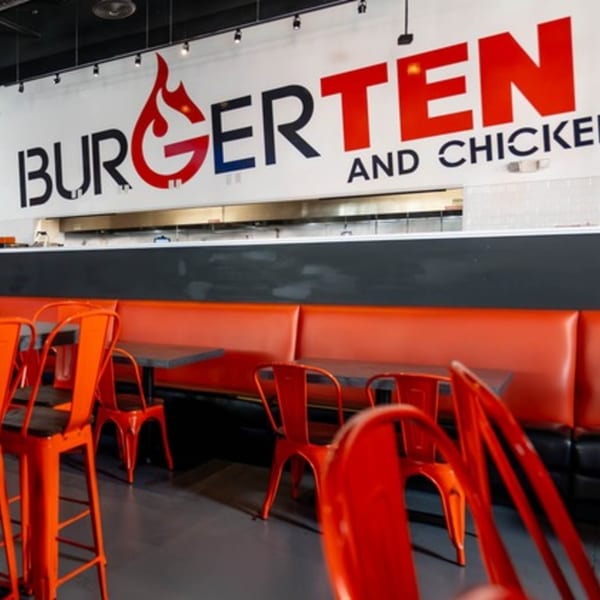 Interior of BurgerTen and ChickenToo with red chairs, tables, and a long red booth.